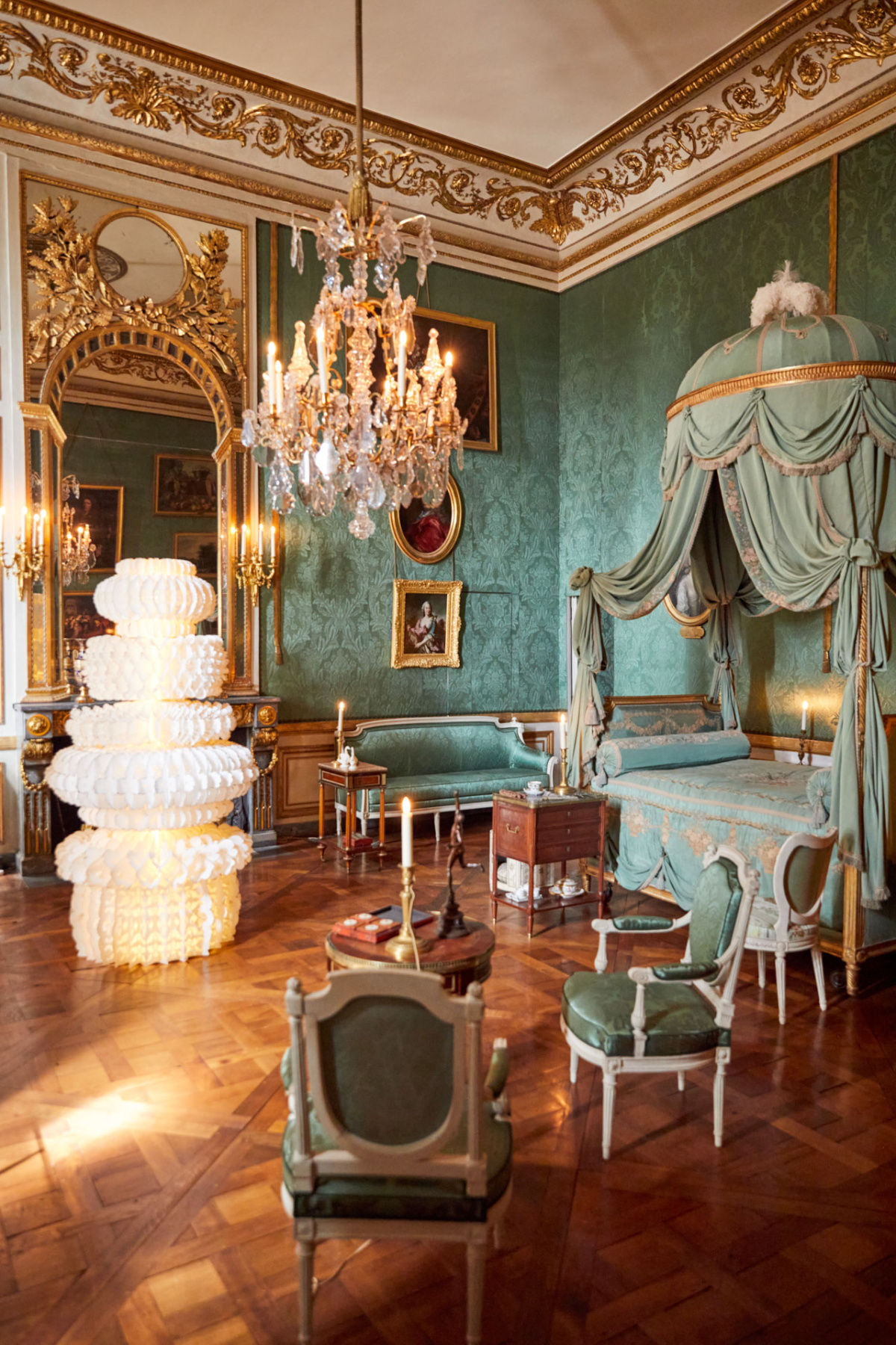 White tiered paper lantern standing in an ornate green and gold bedroom