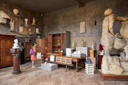 Contemporary design objects displayed among plaster sculptures in a studio